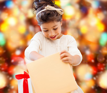 holidays, presents, christmas, childhood and people concept - smiling little girl with gift box over red lights background